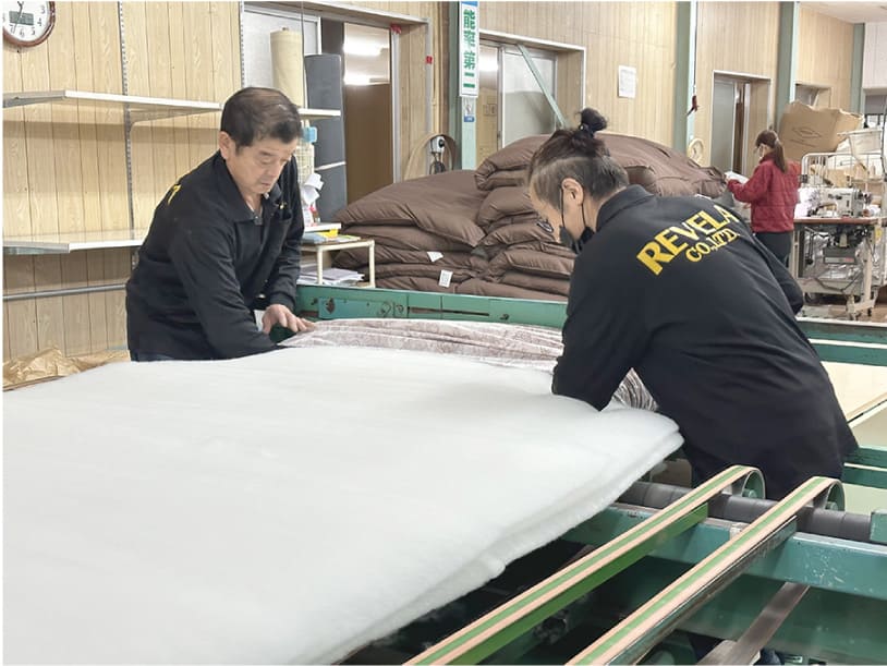 手作業で中綿を側生地内に詰め込む